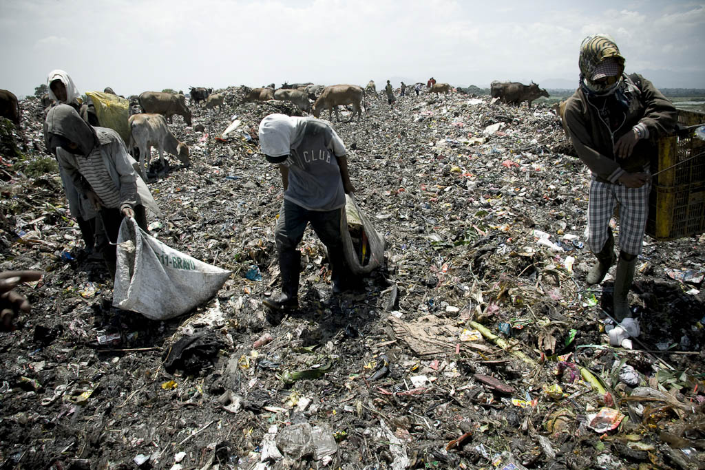 Three guys seeking the emergence of the precious plastic. Makkasar dump. Sulawesi. Indonesia.